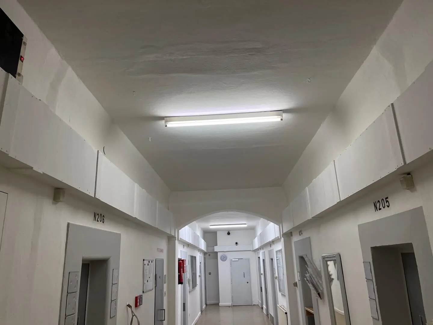 Langer Kellerflur einer Wohnanlage mit Türen zu den Kellerräumen.