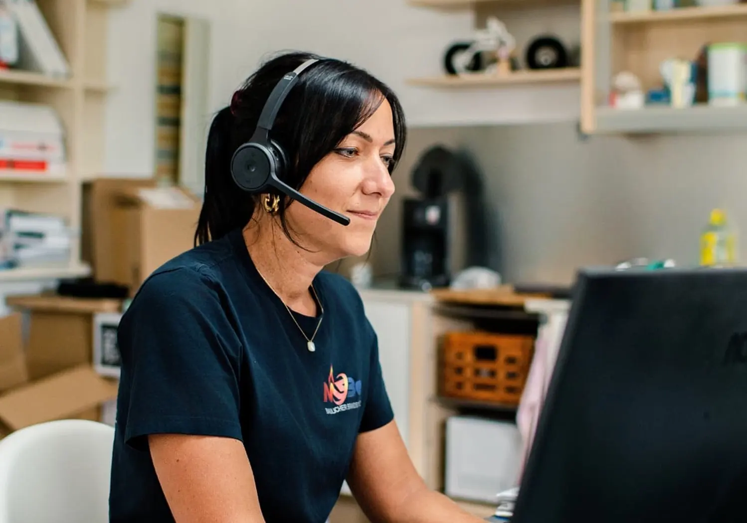 MBe-Mitarbeiterin im Büro mit Headset bei der Terminkoordination